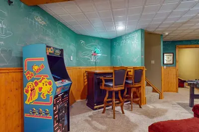 a room with a pinball machine and a table and chairs at Northridge 197 in Tannersville