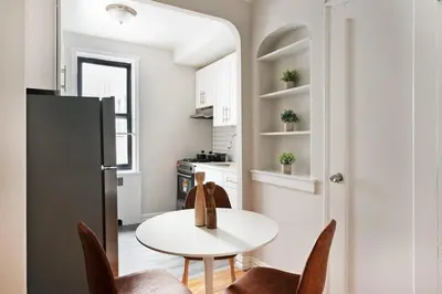 a small kitchen with a white table and chairs at 105 -5G Brand New Studio prime location Elevator in New York