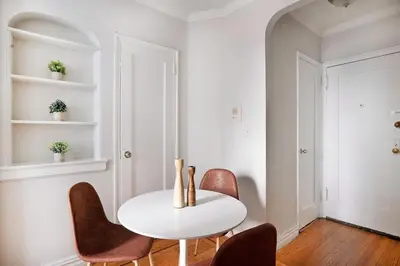 a white dining room with a white table and chairs at 105 -5G Brand New Studio prime location Elevator in New York