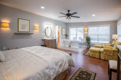 a bedroom with a bed and a bathroom with a sink at Cameron Estate Inn in Mount Joy