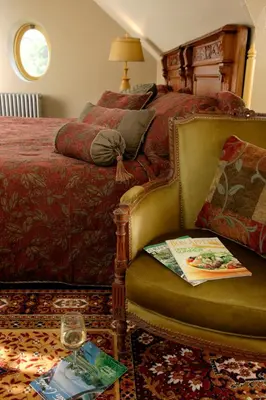 a bedroom with a bed and a chair with a book at Cameron Estate Inn in Mount Joy