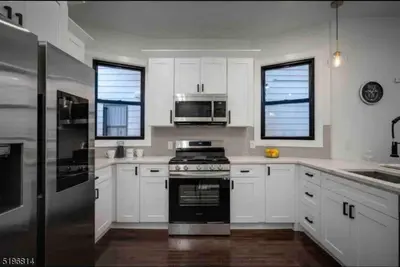 a kitchen with white cabinets and a stove top oven at Secret Escape 20 Min from NYC N 1 in Jersey City