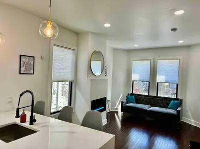 a living room with a couch and some windows at Secret Escape 20 Min from NYC N 1 in Jersey City