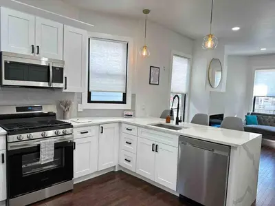 a kitchen with white cabinets and a stove top oven at Secret Escape 20 Min from NYC N 1 in Jersey City