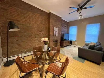 a living room with a glass table and chairs at Liberty Dream - 20 min to NYC in Jersey City