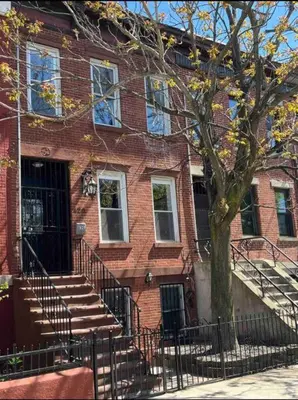 a brick building with stairs and a tree in front at Liberty Dream - 20 min to NYC in Jersey City