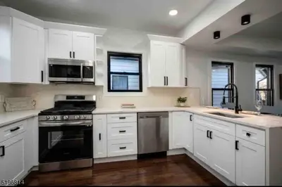 a kitchen with white cabinets and a stove top oven at Secret Escape - 20 min from NYC N 2 in Jersey City