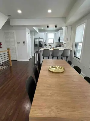 a dining room and kitchen with a long table and chairs at Secret Escape - 20 min from NYC N 2 in Jersey City
