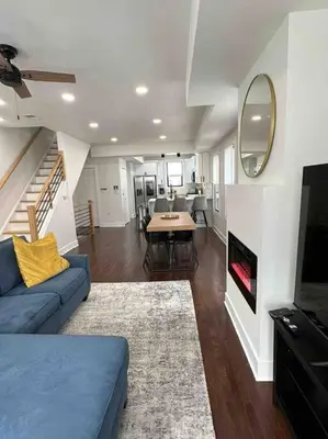 a living room with a blue couch and a fireplace at Secret Escape - 20 min from NYC N 2 in Jersey City