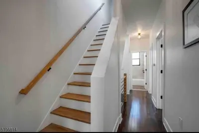 a staircase in a home with white walls and wooden floors at Secret Escape - 20 min from NYC N 2 in Jersey City