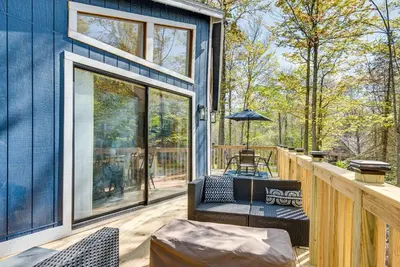a blue house with a deck with a table and chairs at Deck and Community Perks Bright Pocono Lake Home! in Pocono Lake