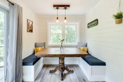 a small dining room with a table and blue benches at Pickleball Court and Fire Pit Milton Cabin! in Milton