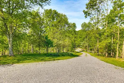 a gravel road in the middle of a forest at Pickleball Court and Fire Pit Milton Cabin! in Milton