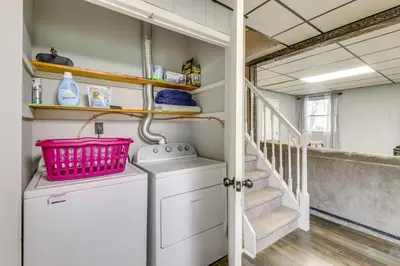 a laundry room with a washer and dryer and stairs at Swim Dock and Game Room Lakefront Poconos Cabin! in Long Pond