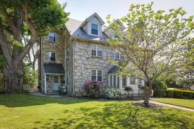 a large stone house with a tree in the yard at Quakertown Vacation Rental Close to Hiking Trails in Quakertown