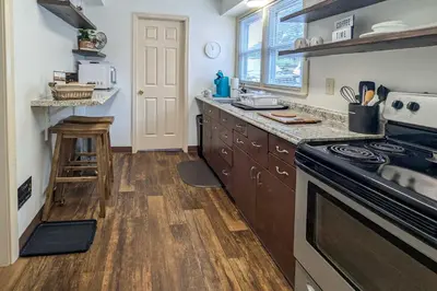 a kitchen with wooden cabinets and a stove top oven at Walk to Restaurants and Shops Apt in Pennsylvania! in Pottstown