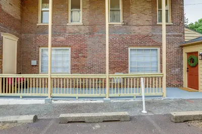 a brick building with a yellow fence in front of it at Walk to Restaurants and Shops Apt in Pennsylvania! in Pottstown