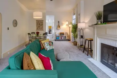 a living room with a green couch and a fireplace at Walk to Restaurants and Shops Apt in Pennsylvania! in Pottstown