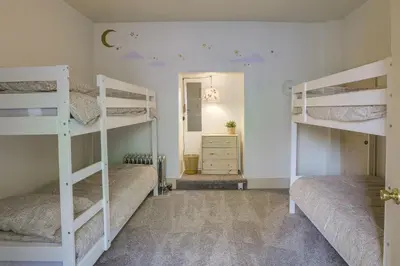 a room with three bunk beds and a mirror at Walk to Restaurants and Shops Apt in Pennsylvania! in Pottstown