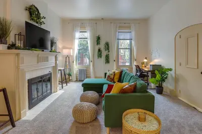 a living room with a green couch and a fireplace at Walk to Restaurants and Shops Apt in Pennsylvania! in Pottstown