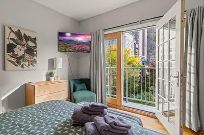 a bedroom with a bed and a large window at StayRafa At 261 4R in Philadelphia