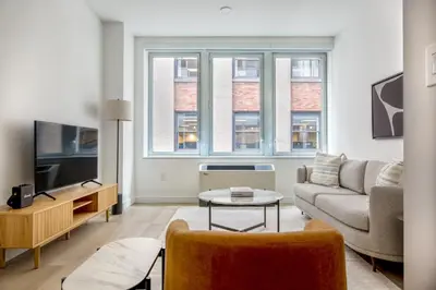 a living room with a couch and a tv at FiDi 1br w gym doorman wd nr Wall St NYC-983 in New York