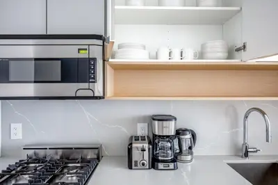 a kitchen with a stove and a microwave at FiDi 1br w gym doorman wd nr Wall St NYC-983 in New York