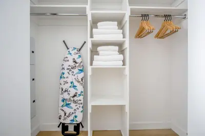 a closet with white shelves and a tie and towels at FiDi 1br w gym doorman wd nr Wall St NYC-983 in New York