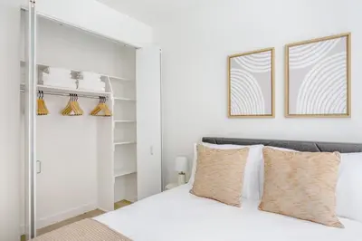 a bedroom with a white bed and two windows at FiDi 1br w gym doorman wd nr Wall St NYC-983 in New York