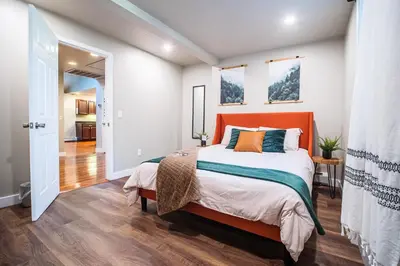 a bedroom with a bed and a hallway at 2 Houses, 22+Guests, 2 Hot Tubs, Renovated, Events Welcome! in Hawley