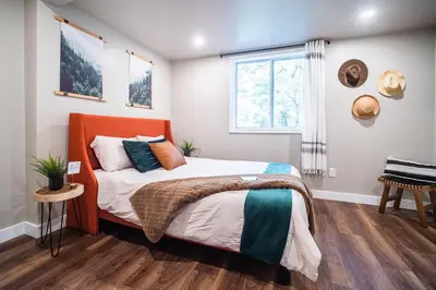a bedroom with a bed with an orange headboard and a window at 2 Houses, 22+Guests, 2 Hot Tubs, Renovated, Events Welcome! in Hawley