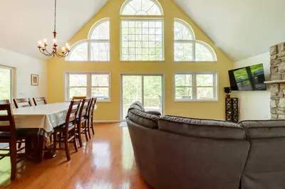 a dining room with a table and a couch at Huge Deck Stunning Pocono Lake Vacation Rental! in Pocono Lake
