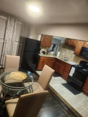 a kitchen with a glass table with chairs and a stove at Comfy & Cozy in East Lansdowne