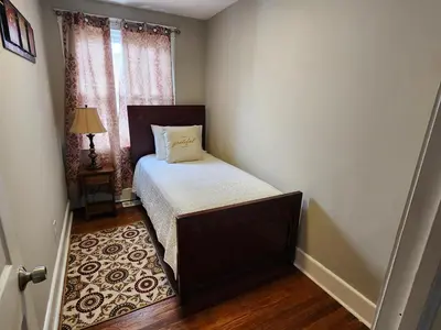 a small bedroom with a bed and a window at Comfy & Cozy in East Lansdowne