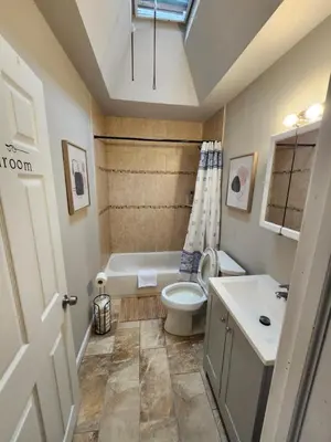 a bathroom with a tub and a toilet and a sink at Comfy & Cozy in East Lansdowne