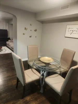 a dining room with a glass table and chairs at Comfy & Cozy in East Lansdowne