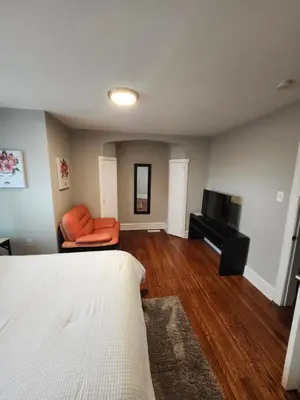 a bedroom with a bed and a couch and a television at Comfy & Cozy in East Lansdowne
