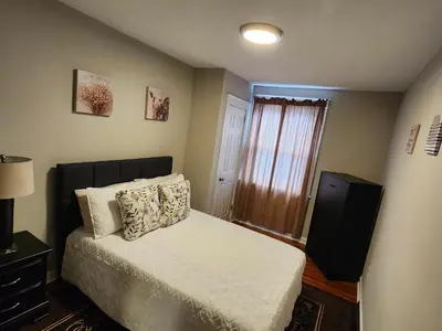 a small bedroom with a bed and a window at Comfy & Cozy in East Lansdowne