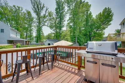 a balcony with a grill and chairs on a deck at Gorgeous Keansburg Home with Pool Walk to Beach! in Keansburg