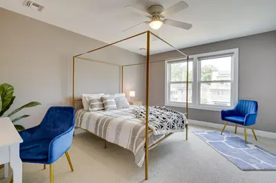 a bedroom with a bed and two blue chairs at Gorgeous Keansburg Home with Pool Walk to Beach! in Keansburg