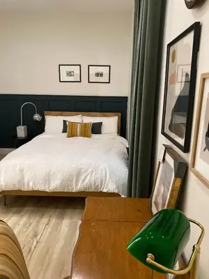 a bedroom with a bed and a green chair at Designer Home 2 Bedroom - 20min to NYC WTC - Private Backyard in Harrison