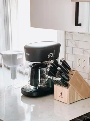a black mixer on a counter with a box of knives at Designer Home 2 Bedroom - 20min to NYC WTC - Private Backyard in Harrison