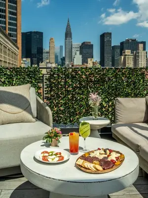 a table with two plates of food on a patio at The Marmara Park Avenue in New York