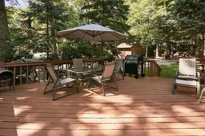 a patio with a table and chairs and an umbrella at The country house in Greenwood Lake