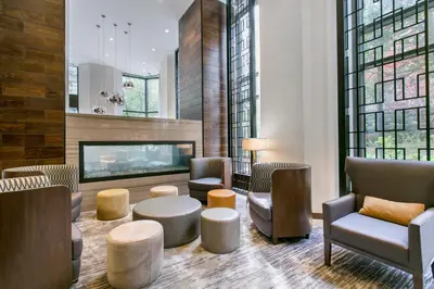 a lobby with chairs tables and a fireplace at Tribeca Studio w Pool Roofdeck Gym View NYC-273 in New York