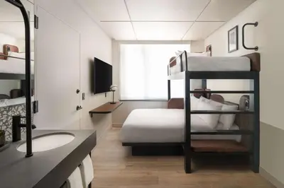 a bedroom with a bunk bed and a bathroom at Motto By Hilton New York City Times Square in New York