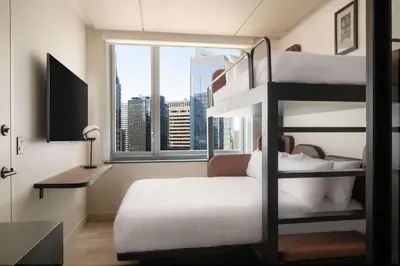 a bedroom with bunk beds with a view of the city at Motto By Hilton New York City Times Square in New York
