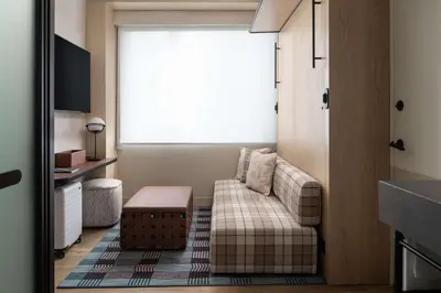 a living room with a couch and a window at Motto By Hilton New York City Times Square in New York