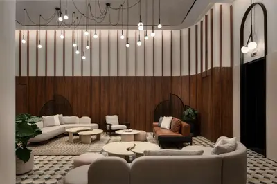 a lobby with couches and tables and a chandelier at Motto By Hilton New York City Times Square in New York