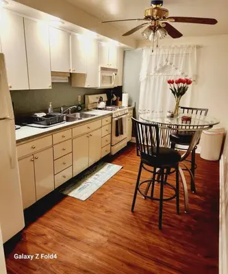 a kitchen with a table and chairs and a kitchen with white cabinets at Cozy 1 Bedroom Business Suite in Philadelphia